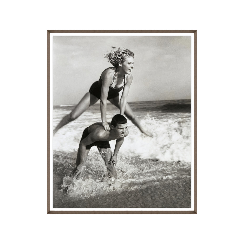Young Couple Playing Leapfrog in the Surf