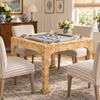 A large rectangular wooden dining table with a blue game board and multiple upholstered chairs in a bright, traditional dining room.