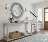 Foyer with a console table, mirror, and decor items against a white wall.