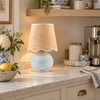 Sea glass blue ceramic table lamp with a woven raffia shade styled on a kitchen coffee nook