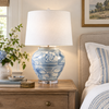 Large Tisbury blue and white hand-painted ceramic table lamp styled on a wood nightstand in a refined coastal bedroom